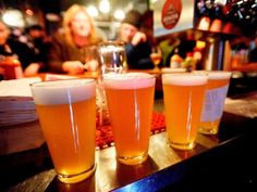 three glasses of beer sitting on top of a table