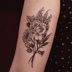 a black and white flower tattoo on the right arm, with flowers in it's center