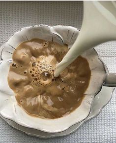 a white bowl filled with brown liquid being poured into it