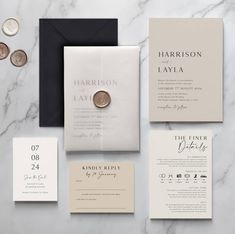 the wedding stationery is laid out on a marble table