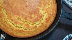 a skillet with some bread in it on top of a table next to utensils