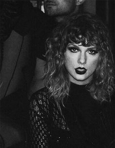 black and white photograph of a woman with curly hair sitting on a man's lap