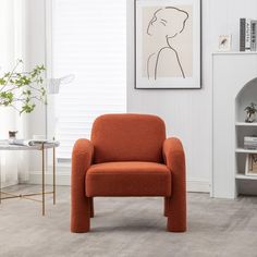 an orange chair in a living room next to a book shelf with books on it