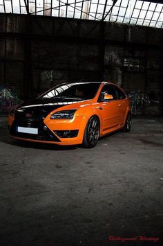 an orange car is parked in the dark