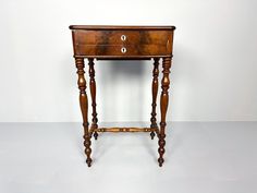 an old wooden table with two drawers on one side and a drawer on the other