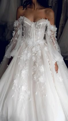 a woman in a white wedding dress with flowers on it