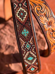 a leather belt with beaded designs on it