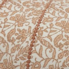 an orange and white floral design on a piece of material that has been stitched together