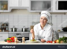 a woman in chef's hat sitting at the kitchen table with food and vegetables