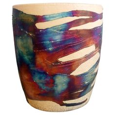 a ceramic vase with multicolored paint on it