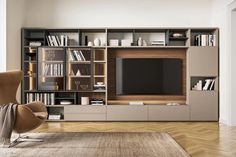 a living room with an entertainment center and bookshelves on the wall in front of it