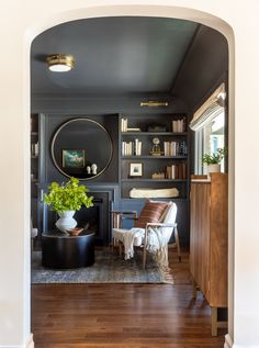 a living room filled with furniture and a fire place under a mirror on the wall