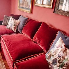 a living room with red couches and pictures on the wall