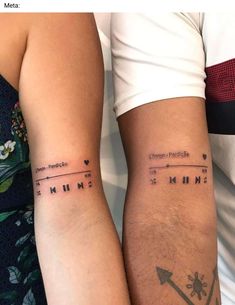 two people with matching tattoos on their arms, one is holding the other's arm