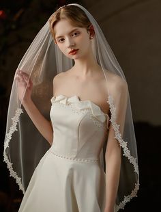 a woman wearing a white wedding dress and veil