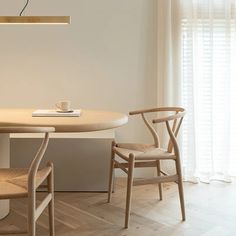 a table with two chairs and a light hanging from the ceiling in front of it