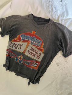 True Vintage 1980s Original Styx Rock Band Paradise Theatre 1981 World Tour Double Sided Thrashed Crop Tee Shirt Size On Tag: none Modern Size: M Measurements in inches, laid flat: (Double for circumference) Pit to Pit: 17 Waist: 17.5 Hip/bottom edge: 17.5 Length shoulder to bottom: 18.5 Shoulder seam to shoulder seam: 14   Cotton All vintage items have been given estimated ages based on quality, materials, design and features of the pieces. These are estimates and not exact.  All items are in wearable vintage condition, unless otherwise stated. We do our best to show any major issues like rips or discoloration in photos of the item.  Measurements are taken by hand. Vintage Tee Shirt Designs, Crop Tee Shirt, Vintage Band T Shirts, Cropped Tee Shirt, Vintage Tee Shirts, Concert Tees, Concert Tshirts, Tee Shirt Designs, Tour Shirt