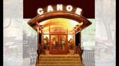 the entrance to a restaurant with stairs leading up to it and an open door that says canoe