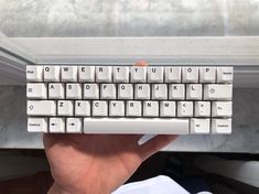 a person is holding a computer keyboard in their hand