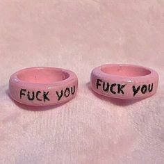 two pink bracelets with words written on them