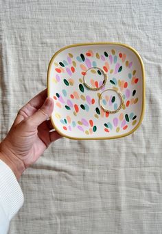 a hand holding a tray with two rings on it