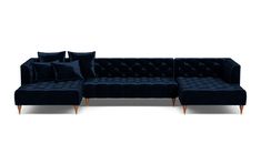 a blue velvet couch with pillows on it