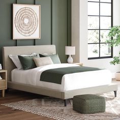 a bedroom with green walls and a white bed in the middle, along with a rug on the floor