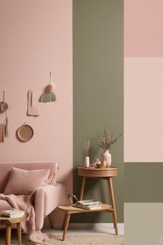 a living room with pink, green and grey colors on the walls next to a coffee table