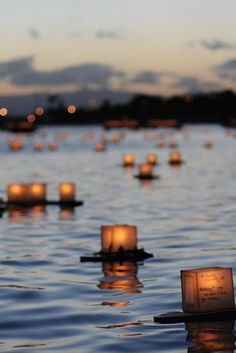 candles floating in the water at dusk