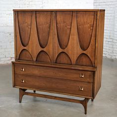 an old wooden cabinet with two drawers on one side and three doors on the other