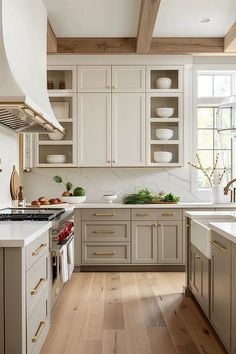 a kitchen filled with lots of white cabinets and counter top space next to a stove top oven