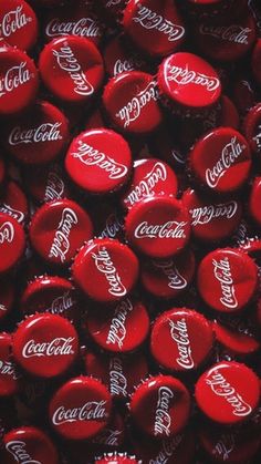 many red coca cola bottle caps are stacked on top of each other in this close up photo