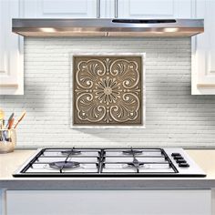 a stove top oven sitting inside of a kitchen next to a white brick wall and cabinets