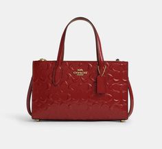 Coach Nina Small Tote Bag In Signature Leather Color: Gold/ Red Brand new with tags 100% Authentic Style Number CV400 Measurements Length: 9.75" Height: 6.25" Width: 3.5" Materials Signature patent leather and smooth leather Fabric lining Handle Handles with 4.50" drop Strap Detachable strap with 22.50" drop for shoulder or crossbody wear Features Inside multifunction pocket Magnetic snap closure Side zip compartments Four protective feet at base Canvas Leather Tote Bag, Canvas Leather Tote, Coach Tote Bags, Barrel Bag, Small Tote Bag, Leather Shoulder Handbags, Fancy Bags, Tote Bag Purse, Coach Leather