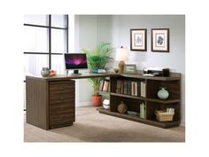 a desk with a computer on top of it in front of a bookcase filled with books