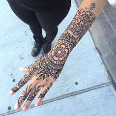 a woman's hand with henna tattoos on it