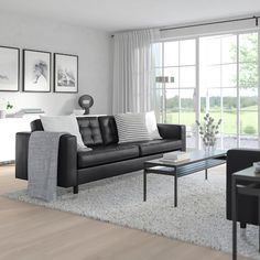 a black and white living room with couches, coffee table and pictures on the wall