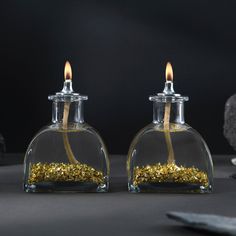 two glass bottles with gold flakes in them