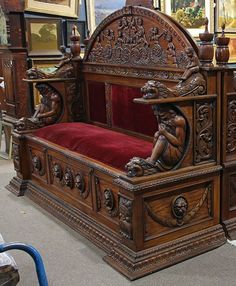 an ornate wooden bed with red velvet upholstered