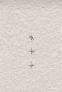 three snowflakes are shown in the middle of a white paper background with black ink