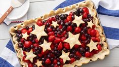 an american flag pie with berries and stars on top is ready to be served for the fourth of july