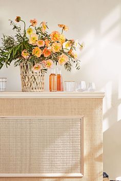 flowers in vases sitting on top of a dresser