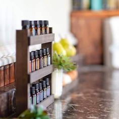 an assortment of essential oils on a shelf in a room with white walls and marble countertops