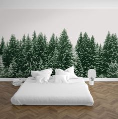 a bed sitting in front of a forest wall mural