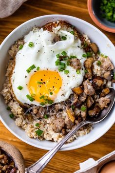 a white plate topped with rice and an egg next to a jar of ketchup