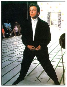 a man in a tuxedo is posing for the camera