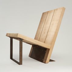 a wooden chair sitting on top of a white floor next to a piece of wood