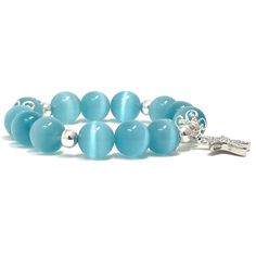 a blue bracelet with silver beads and a cross