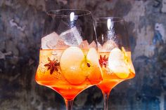 two wine glasses filled with oranges and ice