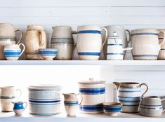 a shelf filled with lots of white and blue dishes on top of eachother